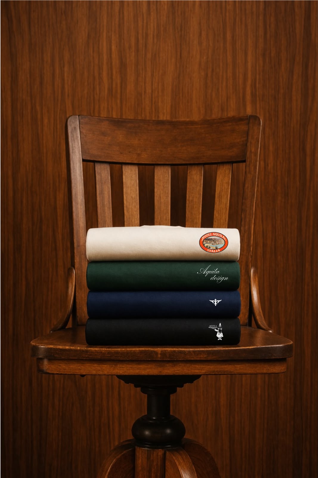 AQUILA FW26 — pilha de camisetas em off-white, verde, navy e preto